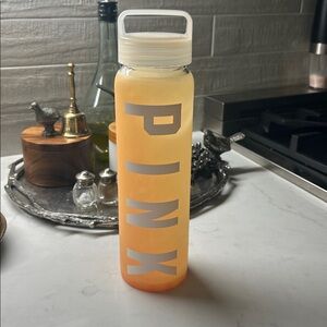 Pink Victoria’s Secret glass Water Bottle. With plastic top. Light orange color